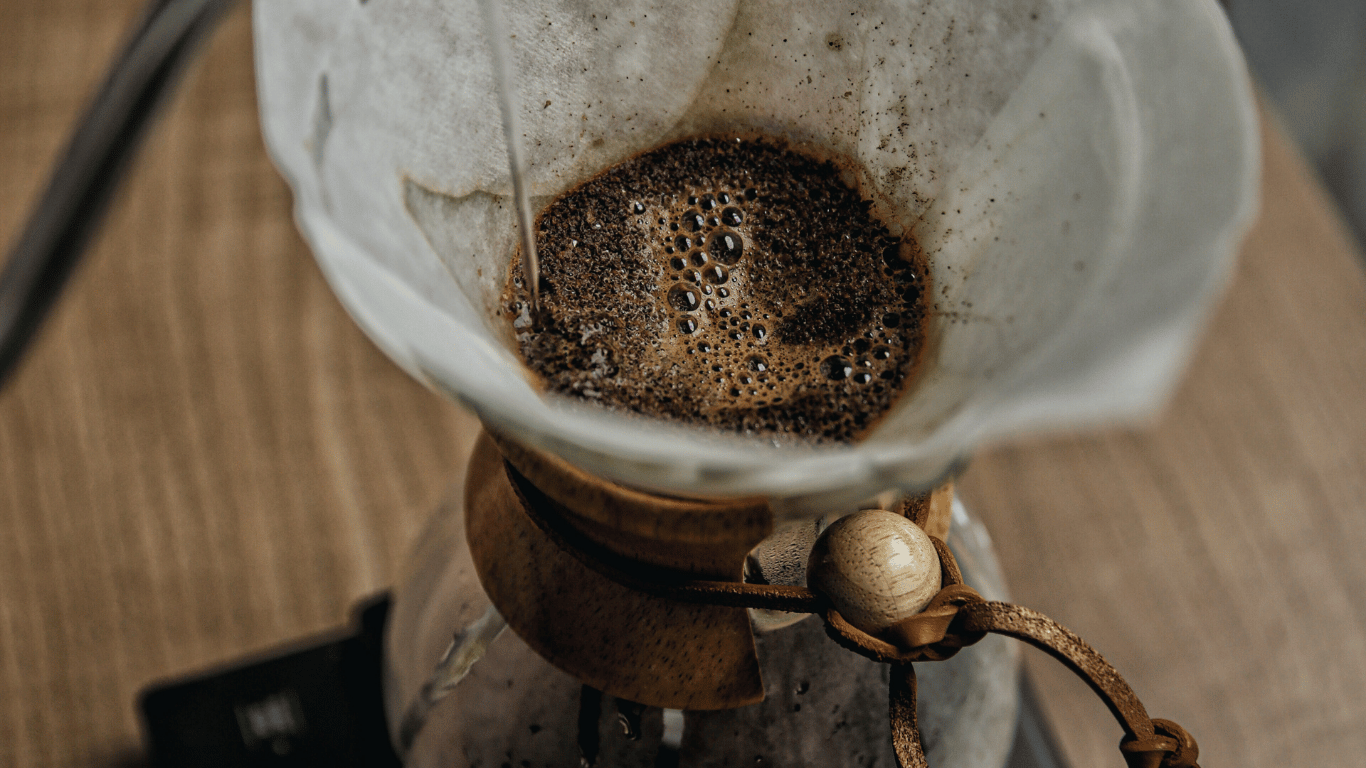 Chemex kaffe brygges med tykt papirfilter, hvor varmt vand hældes langsomt over friskkværnet kaffe for en ren og elegant kop.