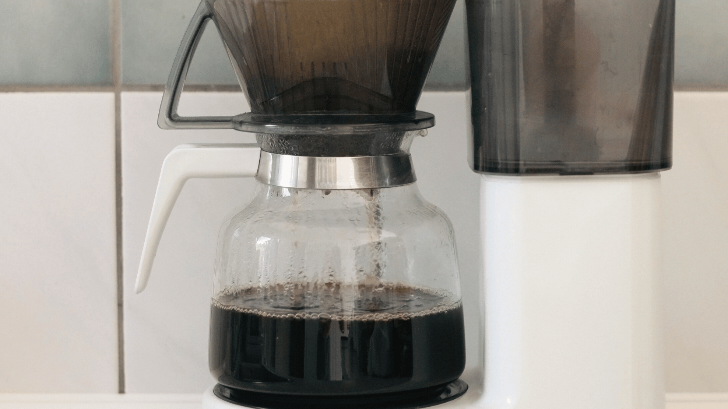 Filterkaffe brygges på kaffemaskine med friskkværnet kaffe og papirfilter for en ren og balanceret kop.