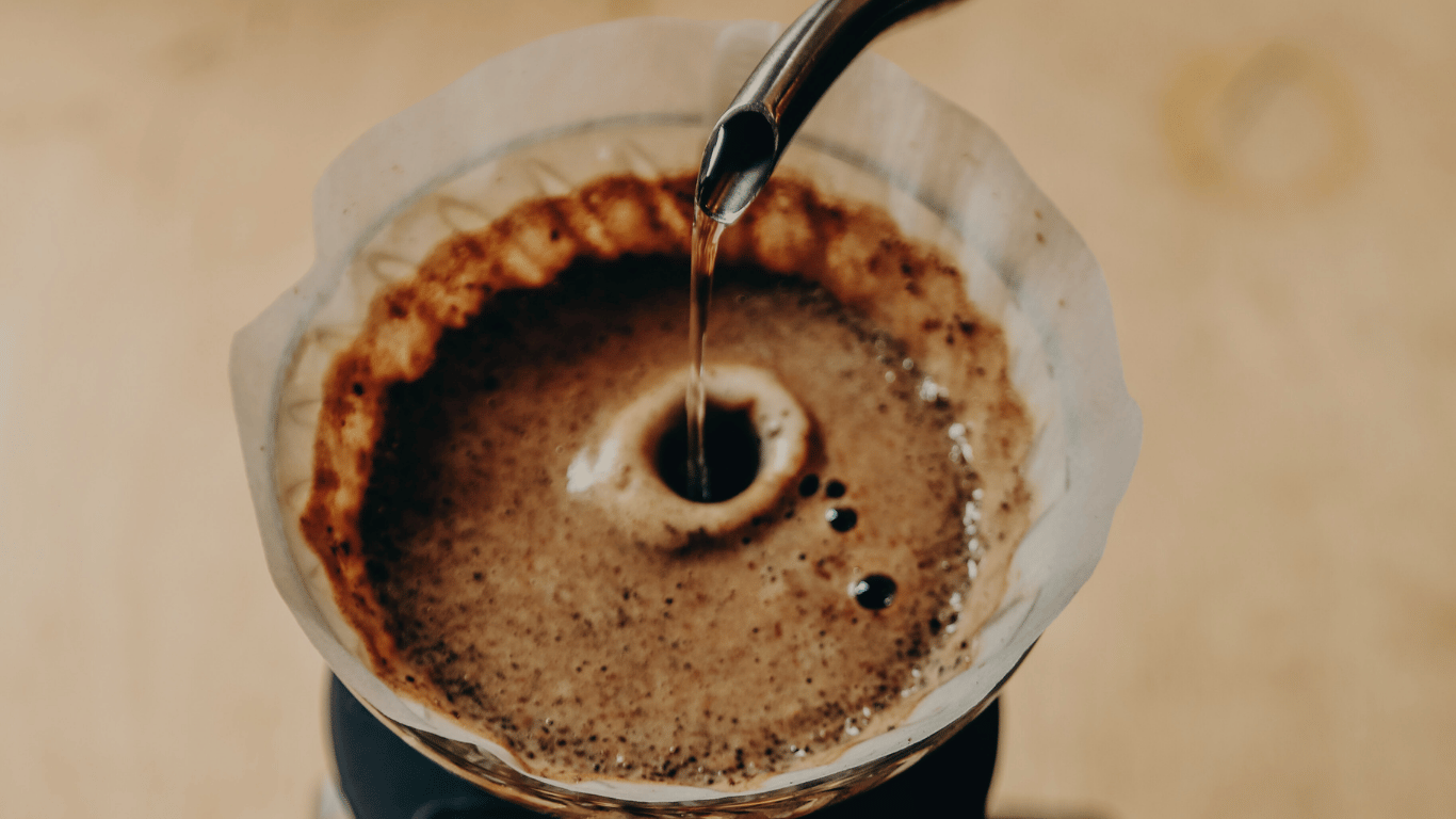 Pour over kaffe brygges med filter og håndbryg, hvor varmt vand hældes langsomt over friskkværnet kaffe for en ren og aromatisk kop.