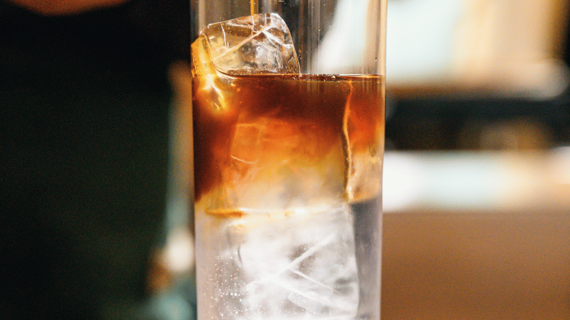 Espresso tonic serveret med is og citrus i glas på sommerdag